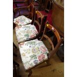 A set of three late Regency mahogany and cane seated sabre leg chairs.