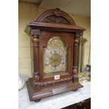 An Edwardian carved walnut mantel clock, striking on gongs, 46.5cm high, with pendulum.