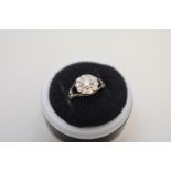 A brilliant cut diamond 'daisy' white gold ring, having diamond set open shoulders, stamped 18ct,