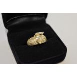 A pear cut diamond gold ring, hallmarked 750, the central diamond 0.67ct and pave set shoulders 0.