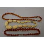 A vintage carnelian bead necklace; together with two other beaded examples. (3)