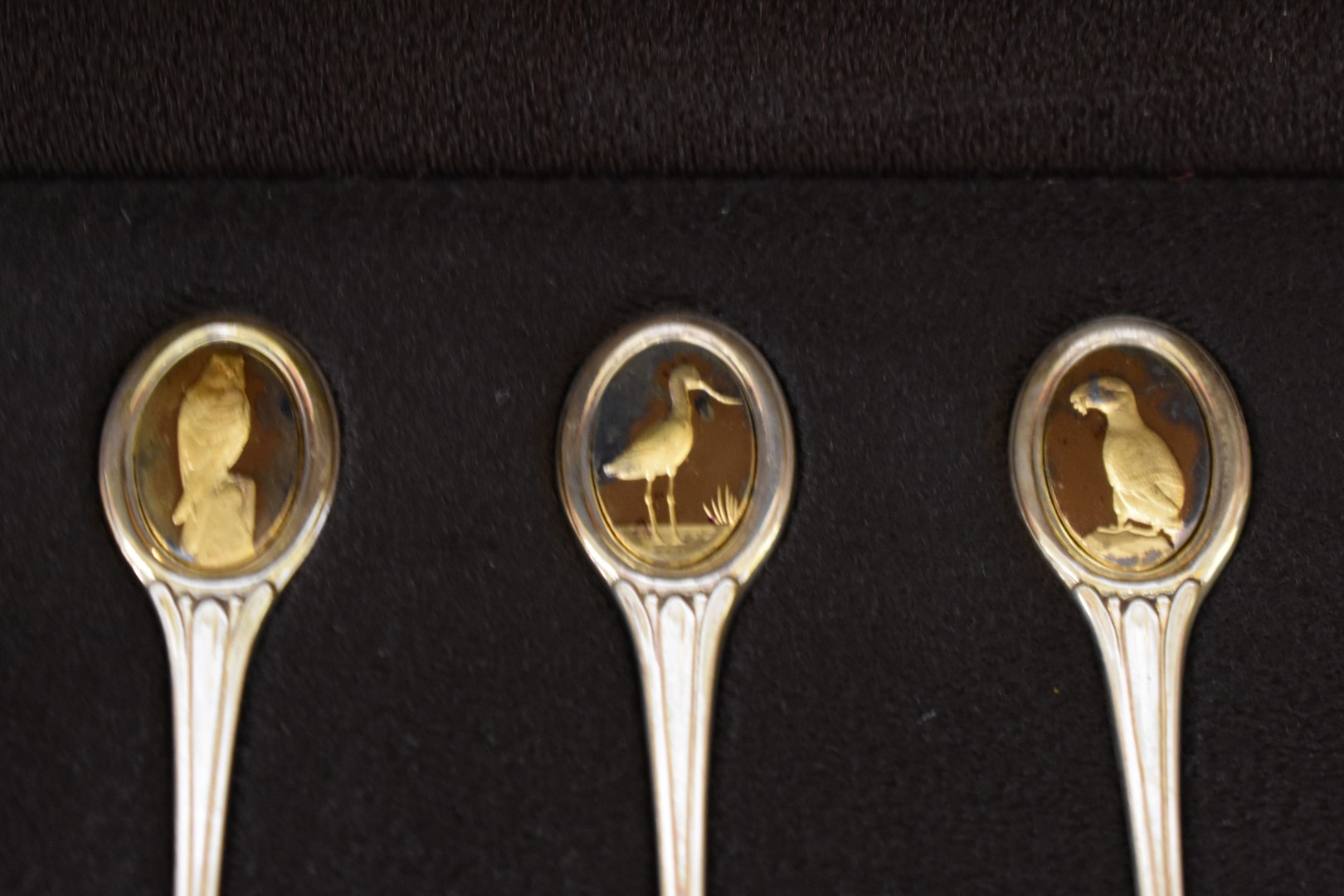 A cased set of twelve RSPB silver and gold tea spoons, by John Pinches, London 1975, 322g, with - Image 2 of 5