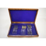 An oak cased part canteen of silver fiddle pattern cutlery, by Barker Brothers, Chester 1907, 1093g.