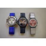 Three Swatch wristwatches.