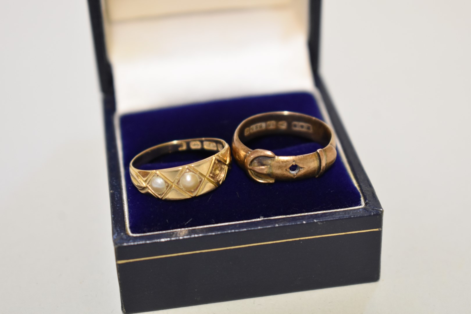 A seed pearl gold ring; together with a gold buckle ring, both stamped 15ct, 4.2g.