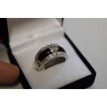 A diamond and onyx dress ring, stamped 750, set emerald and baguette cut diamonds 1.2ct