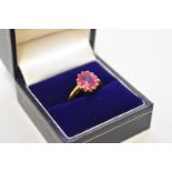 A claw set oval ruby unmarked yellow metal ring, 4.3g total weight.