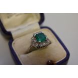 An Art Deco style square cut emerald and diamond unmarked white gold ring, 4.5g total weight.
