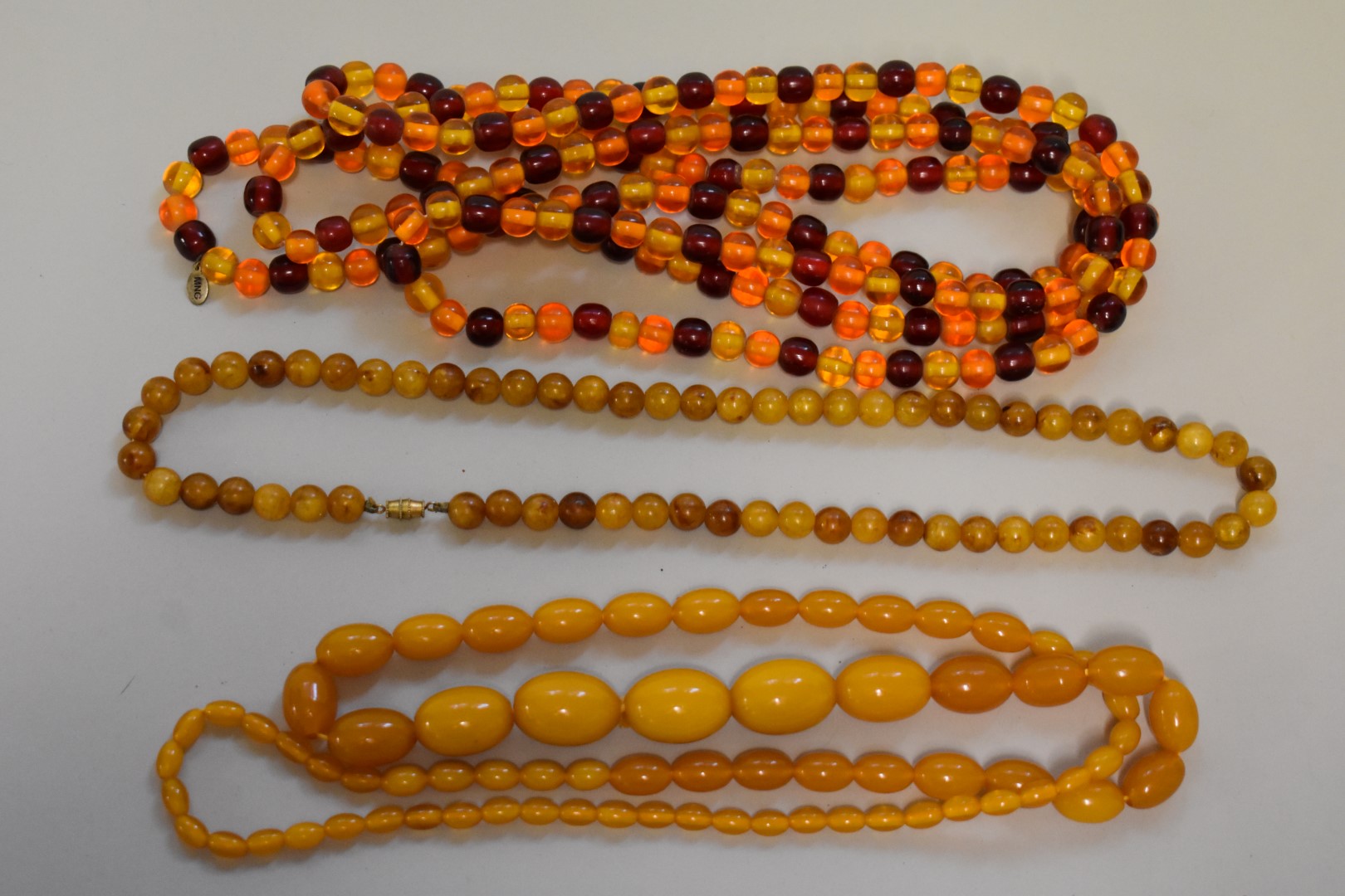 Three strings of amber coloured beads.