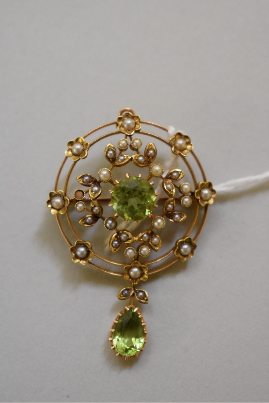 A peridot and seed pearl pendant brooch, stamped 15ct, 45mm, 6.6g total weight.