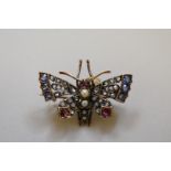 A Victorian 'butterfly' pendant brooch, having mine cut diamond, sapphire and ruby set wings, a