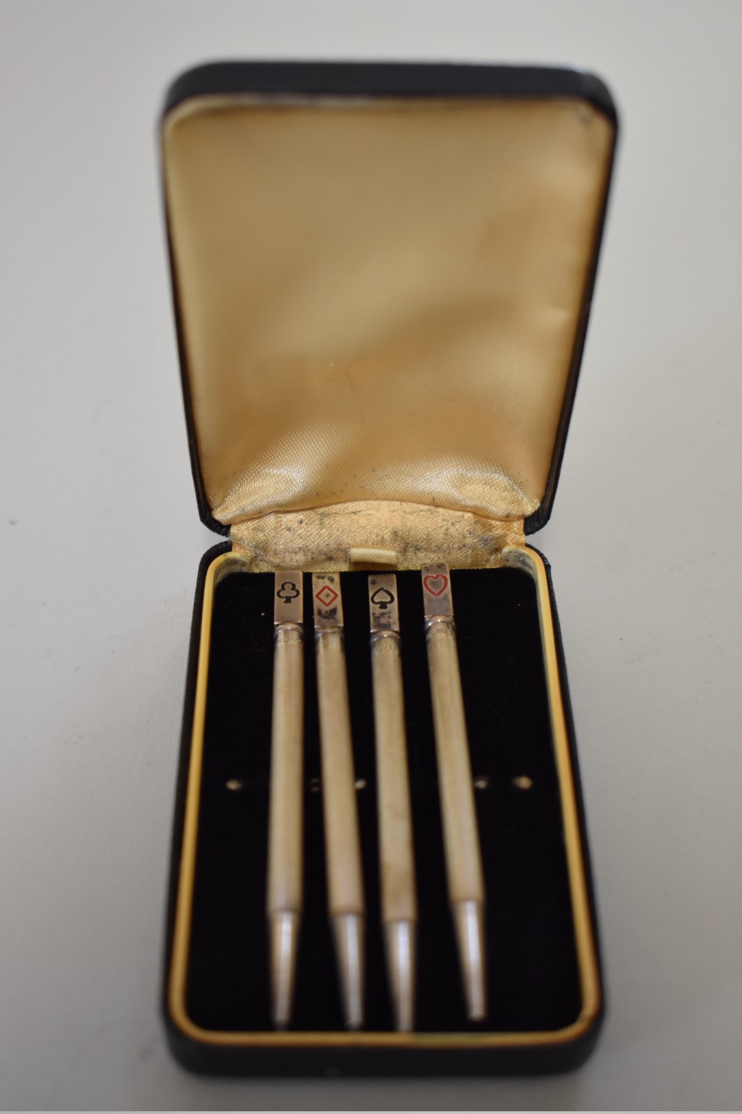 A cased set of four sterling silver engine turned bridge pencils.