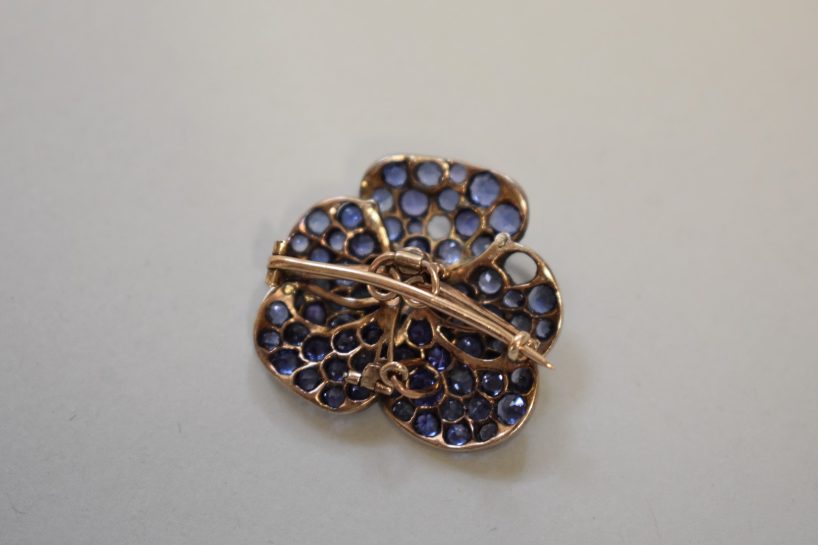 A sapphire and diamond encrusted 'pansy' pendant brooch, set in unmarked yellow metal, 27mm, 9.6g - Image 2 of 3