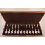 A cased set of twelve RSPB silver and gold tea spoons, by John Pinches, London 1975, 322g, with