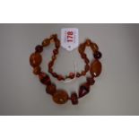 A amber bead necklace, of various colours, shapes and sizes, interspersed with Bakelite beads, 51cm.