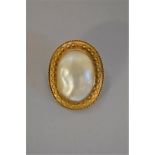 A Victorian baroque mother of pearl oval gold brooch, 3.3 x 2.5cm, 13.2g total weight,