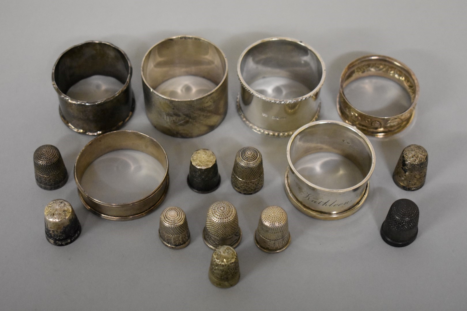 Six various silver napkin rings; together with nine various silver thimbles, 272g weighable.