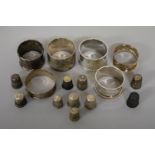Six various silver napkin rings; together with nine various silver thimbles, 272g weighable.