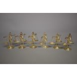 A set of six Oriental metal place name holders, modelled as street vendors carrying baskets,