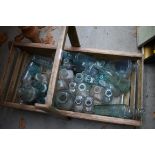 A collection of antique clear glass bottles, in pine trug.