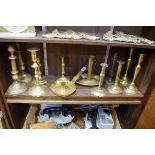 A collection of antique brass candlesticks, to include two pairs. (12)