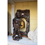 A Chinese bronze table bell, in carved wood stand, 41.5cm high; together with a Chinese carved