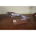 A vintage chrome Jaguar car mascot, mounted on wood plinth, 19cm long.