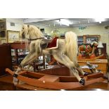 A dapple grey rocking horse, labelled 'De Arte Rocking Horses', 168cm long.