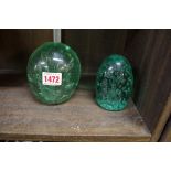 Two green glass dump paperweights, largest 11.5cm high.