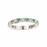 DIAMOND AND EMERALD WEDDING RING.White gold with brilliant cut diamonds. Total approx weight 0.