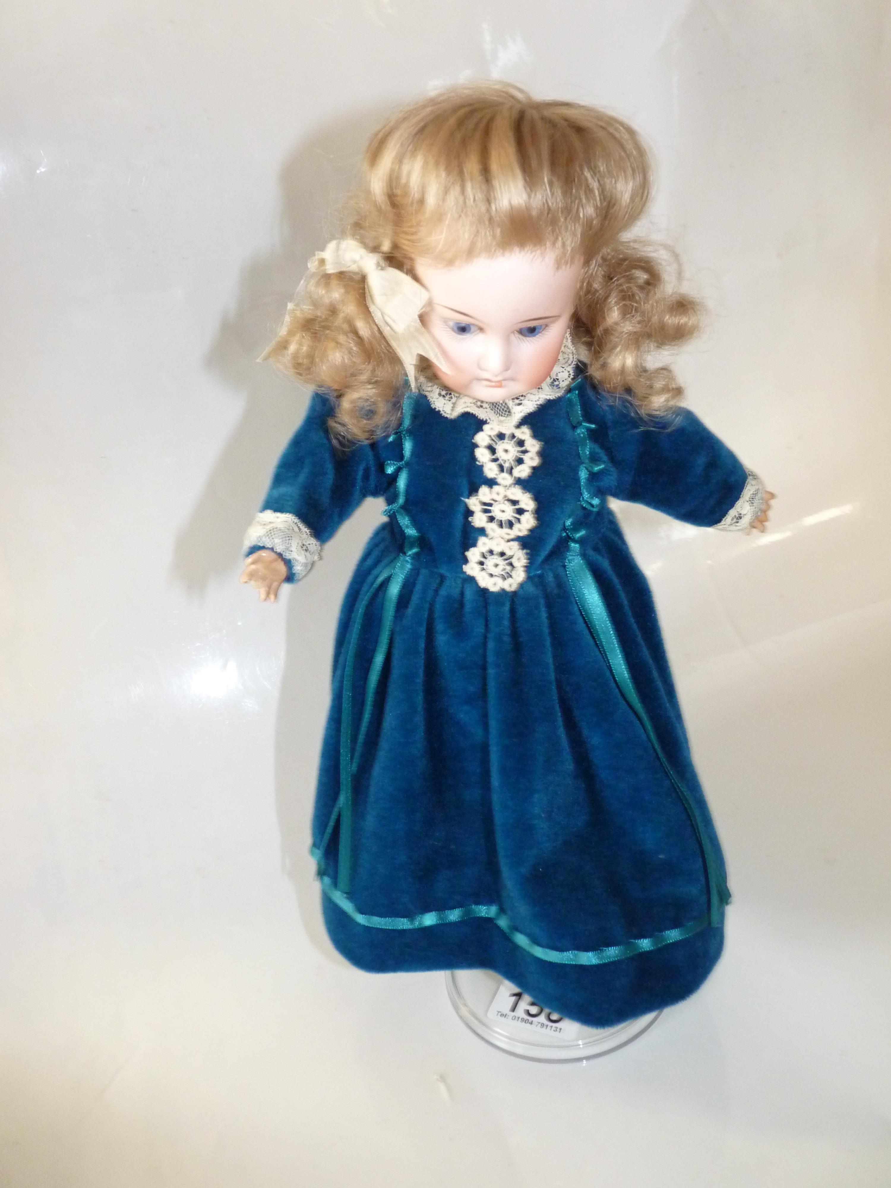 A porcelain doll marked AM 2/dep with articulated body ( finger missing )