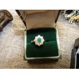 An Emerald and 8 stone diamond ring on 18k gold band