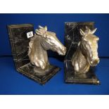 Pair of silver effect bookends on granite stands