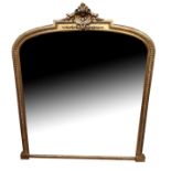 A VICTORIAN GILT FRAMED OVER MANTLE MIRROR With a central cartouche above an arched silvered