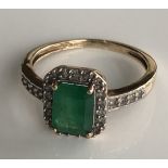 A 9CT GOLD, EMERALD AND DIAMOND RING The emerald surrounded by diamonds (size O).