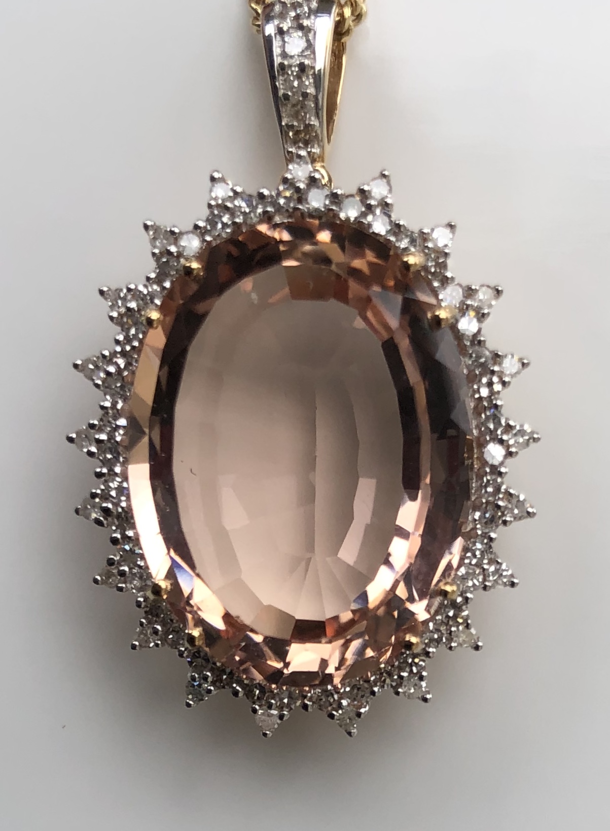 A 9CT GOLD, MORGANITE AND DIAMOND PENDANT The large morganite surrounded by diamonds on a chain. (