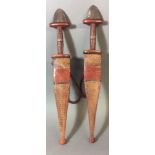 A PAIR OF LATE 19TH/EARLY 20TH CENTURY AFRICAN CROCODILE SKIN BOUND DAGGERS Narrow bound red,