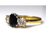 A VINTAGE 18CT GOLD, SAPPHIRE AND DIAMOND THREE STONE RING Th single oval cut sapphire flanked by
