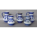 A COLLECTION OF FIVE VICTORIAN WEDGWOOD JASPERWARE JUGS Dark blue grounds, applied with scrolled