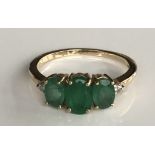 A 14CT GOLD, EMERALD AND DIAMOND RING Having an arrangement of three oval cut emeralds and two small