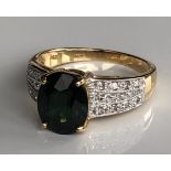 AN 18CT GOLD, INDICOLITE AND DIAMOND RING The oval cut indicolite on diamond shoulders (size O).