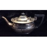 A VICTORIAN SILVER TEAPOT Having an ebonized wooden handle and flutes to body, hallmarked Birmingham