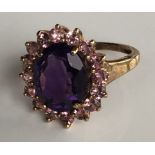 A 9CT GOLD, AMETHYST AND PINK TOURMALINE RING The amethyst surrounded by pink tourmalines (size N).