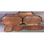 A COLLECTION OF SEVEN ART NOUVEAU COPPER TRAYS Oval form with scalloped edge and engraved floral