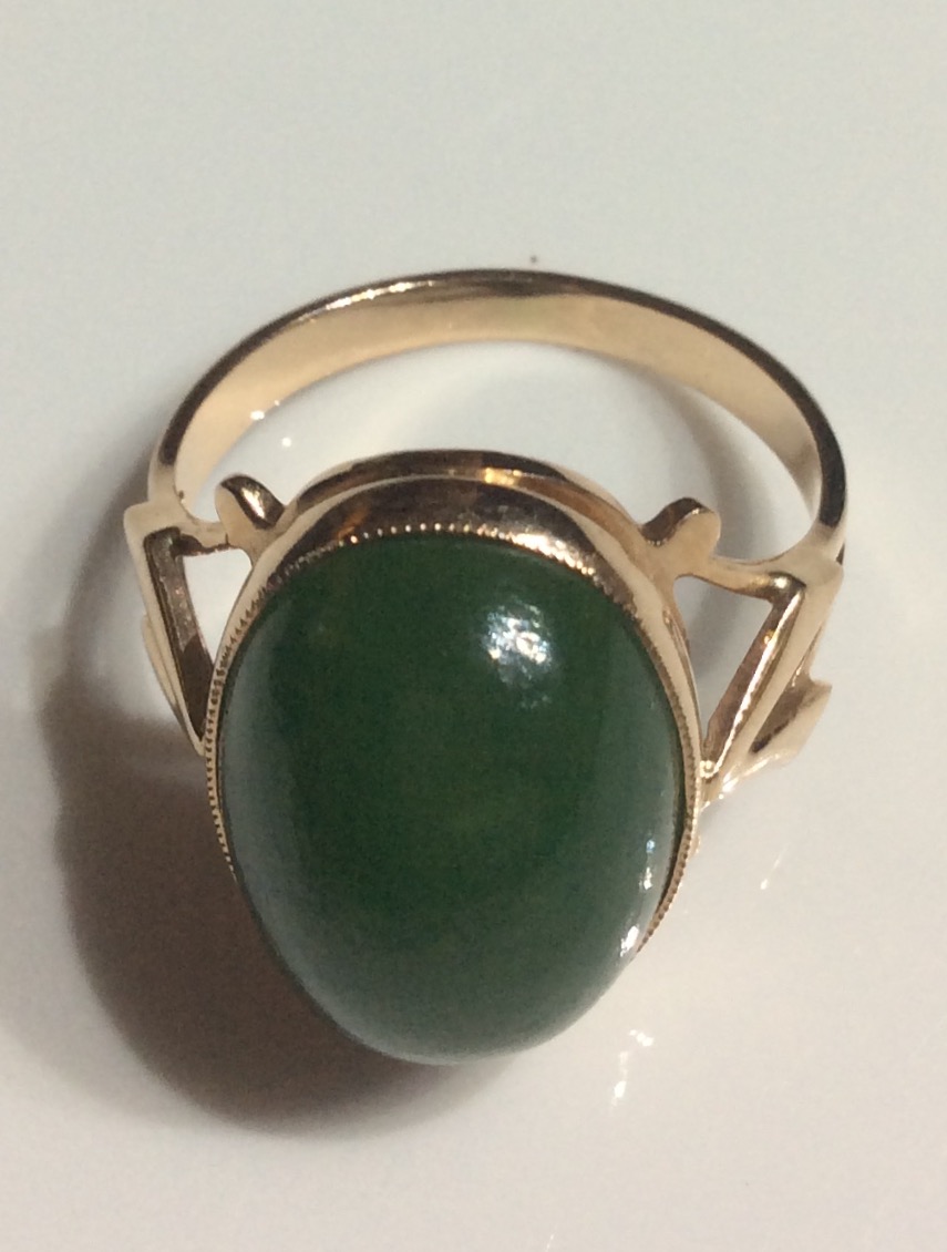 A CONTINENTAL 14CT ROSE GOLD AND JADE RING Having a single cabochon cut stone on a plain gold