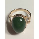 A CONTINENTAL 14CT ROSE GOLD AND JADE RING Having a single cabochon cut stone on a plain gold