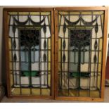 A PAIR OF EARLY 20TH CENTURY FLORAL STAINED GLASS PANELS In pine frames. (72cm x 137cm)