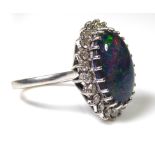 AN 18CT WHITE GOLD, OPAL AND DIAMOND RING The cabochon cut opal edged with round cut diamonds (