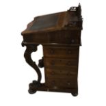 A VICTORIAN ROSEWOOD DAVENPORT DESK With pierced fretwork gallery above a rise and fall writing