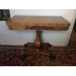 A REGENCY CARVED ROSEWOOD FOLD OVER CARD TABLE The rectangular top raised on four scroll feet.